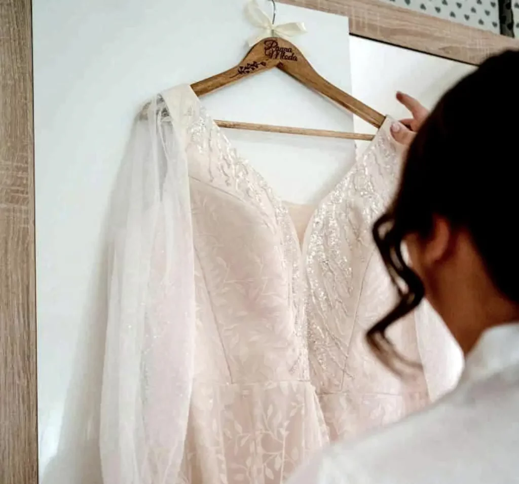 kobieta z suknią na wieszaku