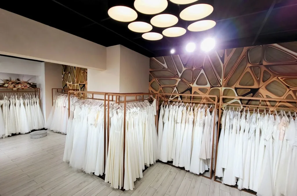 Wnętrze salonu sukien ślubnych z dużym wyborem sukien ślubnych plus size na wieszakach